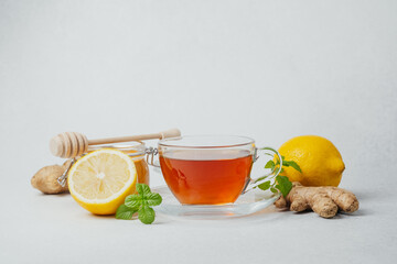 Plakat Cup of tea with lemon, ginger and honey on a light background