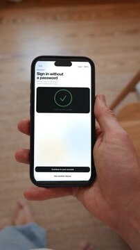 A passkey sign in replaces the password and is confirmed with face recognition. Point of view shot in vertical format with the phone held in the hand. Useful for life without passwords.