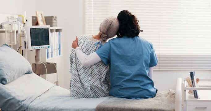 Medical, nurse and old person on hospital bed with hug, comforting and empathy for diagnosis. Back, elderly patient and doctor with consoling, understanding and sympathy for healthcare results.