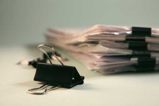 Close up of black binder clip on pile of documents. Business concept.