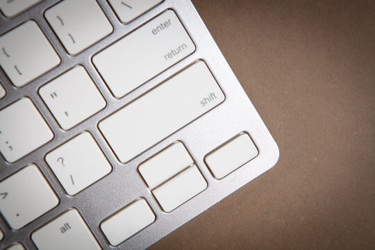 Keyboard of a modern laptop on a brown background.