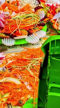 Fresh julienne carrots and shredded vegetables prepared with kitchen slicer tool on display plate.
