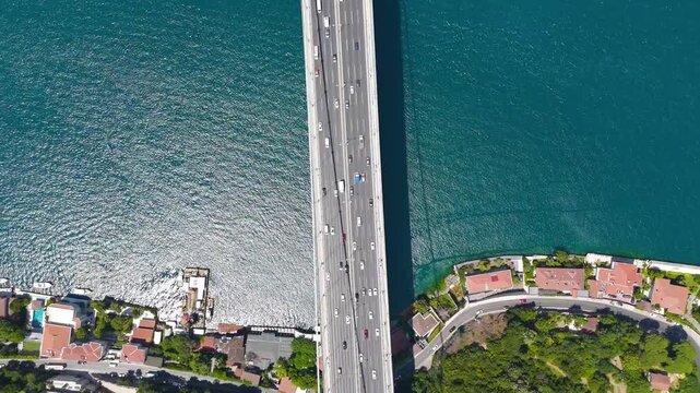 Istanbul, Turkey. Fatih Sultan Mehmet Bridge, gravity-anchored suspension span over the Bosphorus Strait, aerial top-down view with traffic on turquoise waters. Aerial View, HEAD OVER SHOT