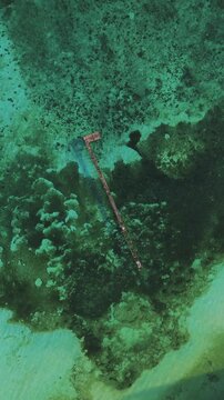 Aerial view of Mios Kri jetty surrounded by vibrant coral reefs and turquoise waters in West Supiori, Papua, Indonesia.