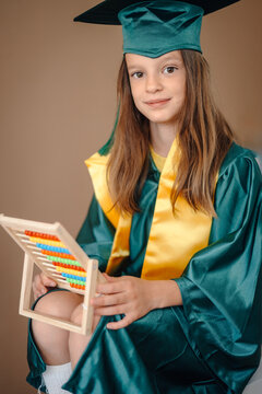 Young child learning with abacus wearing graduation gown