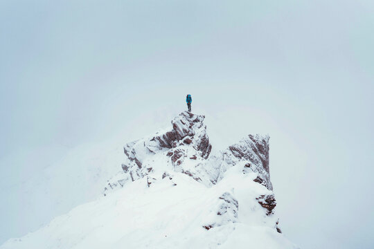 Mountaineer using an ice axe to climb Forcan Ridge in Glen Shiel, Scotland