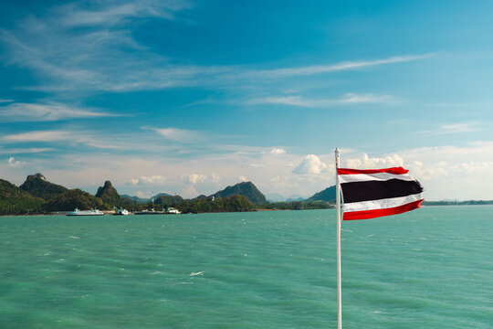 Thai Flag Over Turquoise Sea and Mountainous Coastline