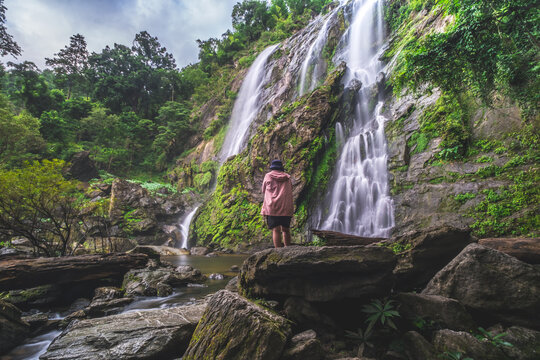 Tourists in Khlong Lan Waterfall in Khlong Lan National Park, Kamphaeng Phet Province, Thailand.