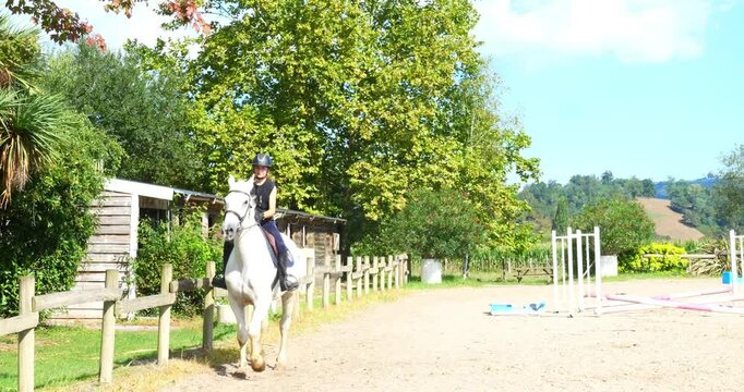 Beautiful young female rider tgalopping on her horse in slow motion