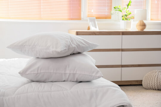 Sleep hygiene and comfort, two white pillows stacked on a bed in a bright bedroom interior for relaxation and wellness lifestyle