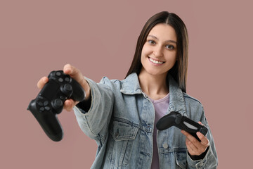 Gaming and entertainment, young woman inviting to play video games with two controllers, leisure activity and digital hobby concept on solid background © Pixel-Shot