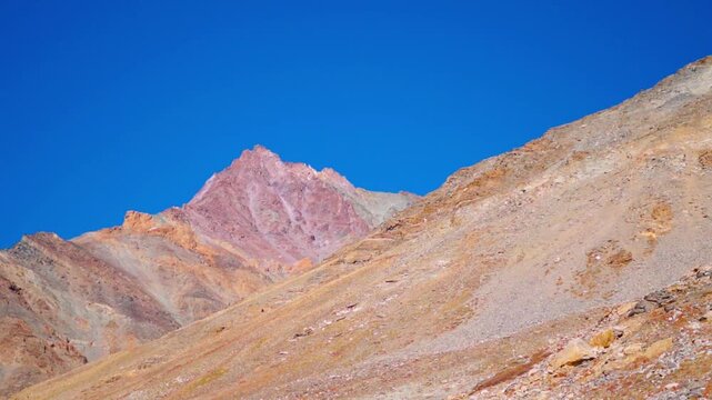Landscape shot of dry Himalayan mountain peak against the blue sky during the autumn season as seen near Kargyak village in Zanskar Valley of remote Ladakh, India. Scenic natural background.
