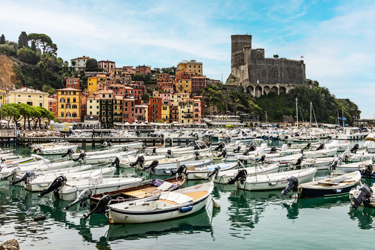 Historic castle overlooking a crowded marina filled with boats in Italy