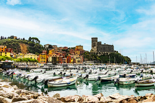 Mediterranean harbor scene with traditional houses and a medieval fortress