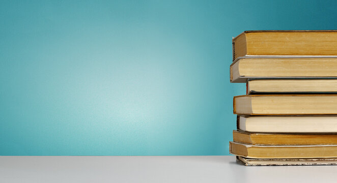 Books stacked on a table with a blue background in a learning environment