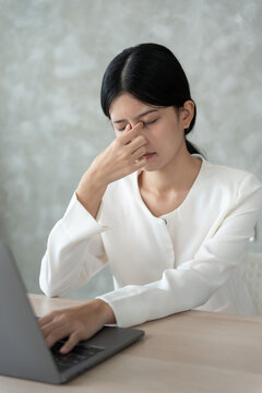 Eye problems, Asian women open eyes due to eye irritation, eye rubbing, dry, eye pain after work, migraine, headache, blurred vision, photophobia, working in the dark, blue light from computer screens