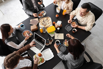Obraz premium Group of business people having lunch at table in office, top view