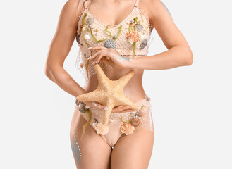 Naklejka premium Beautiful young woman dressed as mythical mermaid with starfish on grey background, closeup