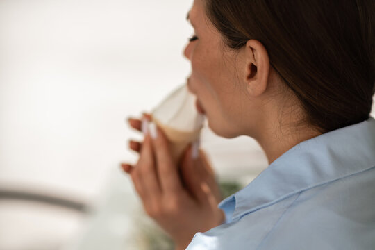 Morning routine featuring a woman sipping coffee for relaxation while enjoying a tasty beverage in a bright indoor setting