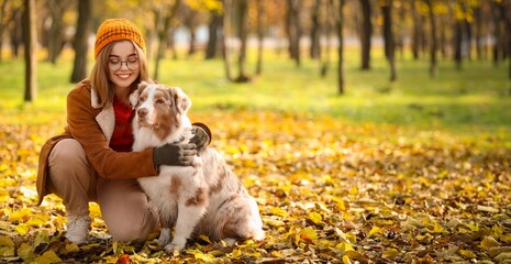 Naklejka premium Pet companionship and mental health, happy woman hugging her dog in an autumn park with golden leaves and seasonal outdoor lifestyle