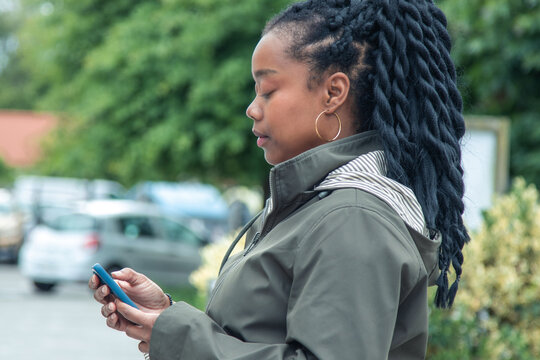 black woman with phone on the street