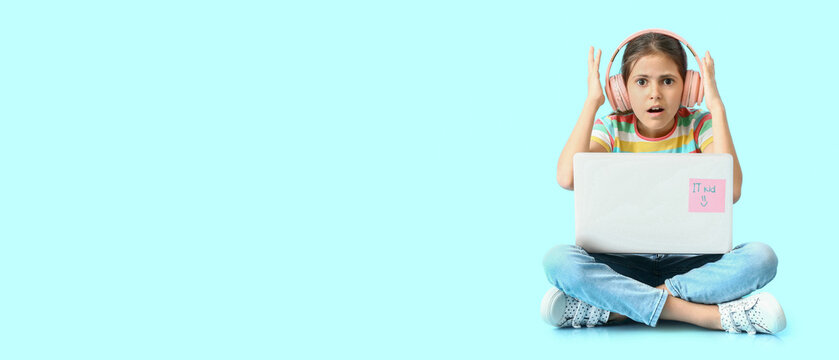 Digital childhood and online learning stress, shocked girl with laptop and headphones experiencing technical difficulties or cyberbullying on blue background