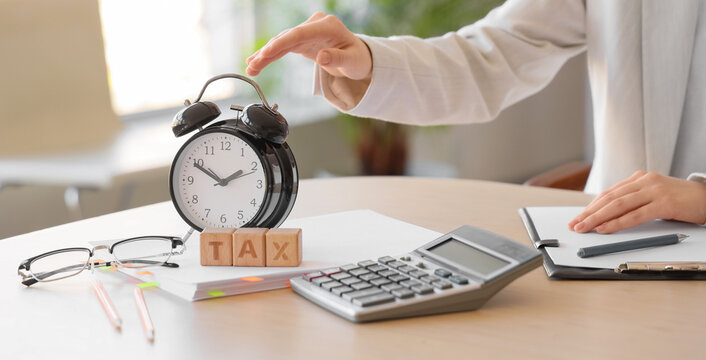 Tax deadline and financial planning, person working with calculator and alarm clock to manage accounting and fiscal responsibility in office environment