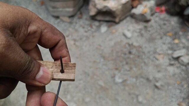 Craftsman Threading and Tying Metal Wire on Bamboo Pole