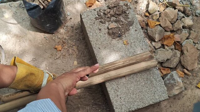 Using Pliers to Tighten Wire Binding on Bamboo Stalks Close Up