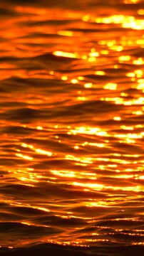 Sunset water reflection shimmering on surface of lake at golden hour creating beautiful natural texture of liquid motion
