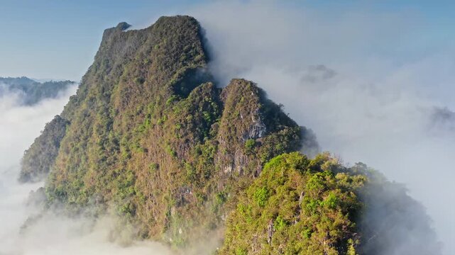 Khao Sok National Park morning landscape. Limestone karsts mountains and lush tropical jungle, dense fog covering valleys. Travel and explore Thailand nature beauty. Aerial view drone flight panorama
