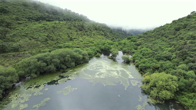 4K drone aerial view of Yala Provincial Park in Jujuy, Argentina. Misty mountain lakes surrounded by lush Yungas forests and dense green vegetation in a spectacular Andean landscape.
