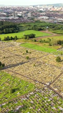 Wide advancing aerial video of Milltown Cemetary in West Belfast, Northern Ireland on a bright summer evening. Produced in 60FPS, 1080x1920 social ratio and with Rec709 colour.