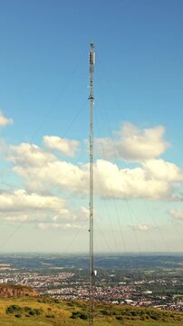 Close-up aerial video of the Black Mountain Television Transmitter Tower in West Belfast, Northern Ireland on a bright summer evening, Produced in 60FPS, 1080x1920 social ratio and with Rec709 colour.