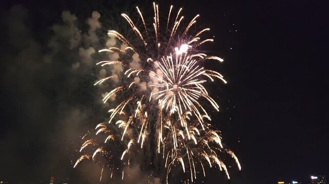 Golden fireworks exploding over city skyline at night