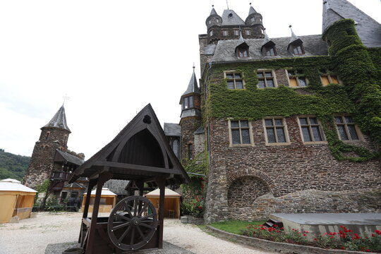 Historic Cochem Castle with ivy-covered walls and a medieval well