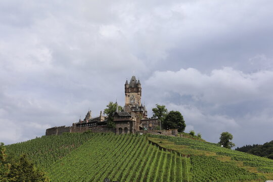 Reichsburg Cochem castle perched atop a vineyard hill in Germany