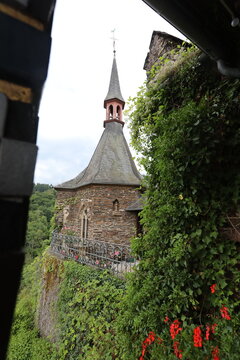 Historic Cochem castle tower with slate roof and ivy-covered walls