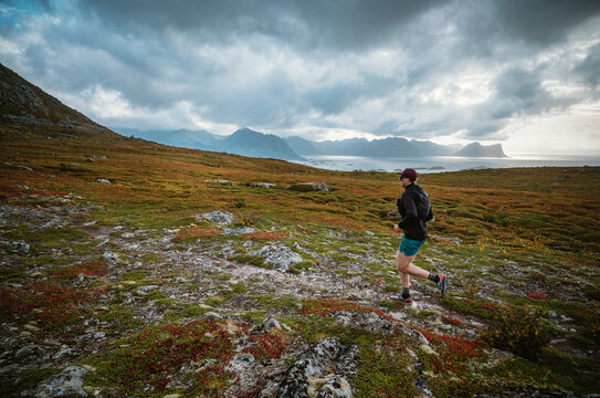 Man trail running along a dramatic coastal mountain