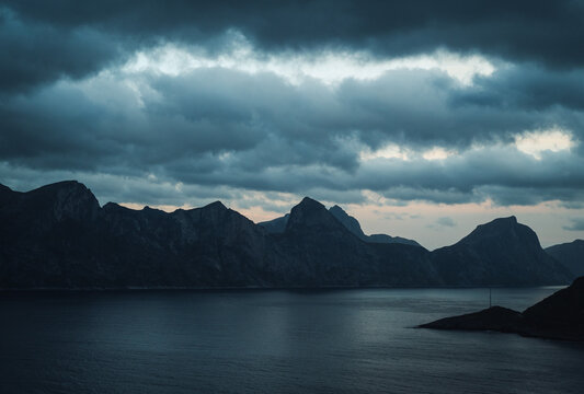 Moody mountain range silhouetted against the sea