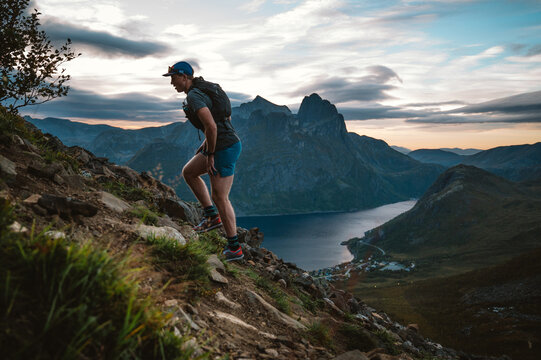 Male runner climbs steep mountain at sunset