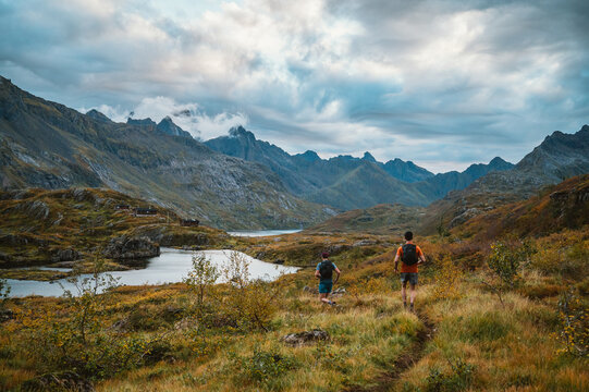 Two men trail running through scenic Norwegian mountains