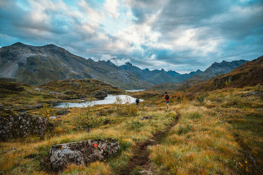 Two men trail running through a vast mountain valley
