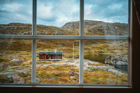 Looking out window at remote cabin in mountains