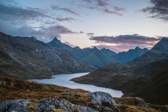 Jagged mountain peaks over a winding river at sunset