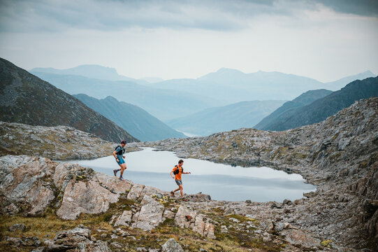 Two men trail running in a dramatic mountain landscape