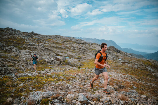 Two men trail running on a rocky mountain path