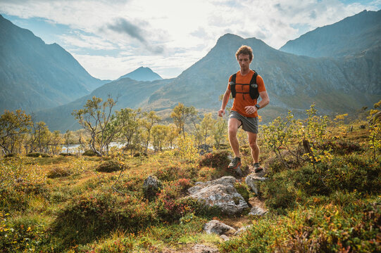 Man trail running on a rocky path in the mountains