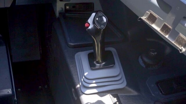 Close up of side stick flight control lever inside modern jet airliner cockpit, pilot input device for fly by wire flight control system, commercial aviation technology and equipment