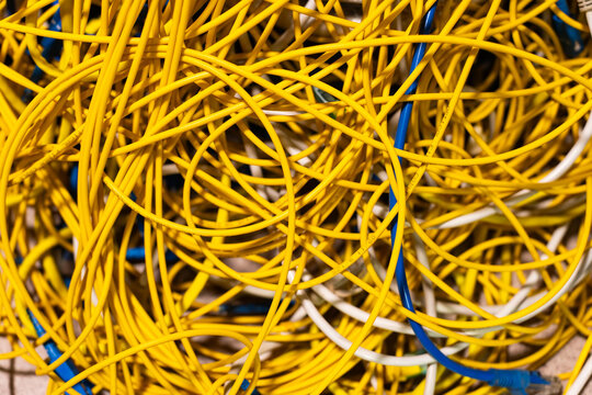 Concept of untidy messy network infrastructure with cables chaotically connected to data center